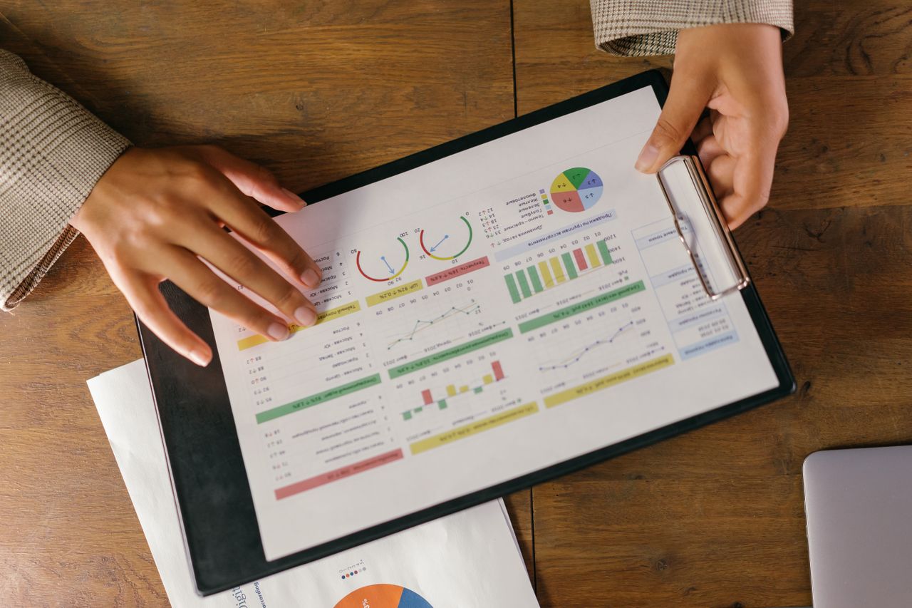 creative-03 Top view of hands holding a financial report with colorful graphs and charts, ideal for business presentations.