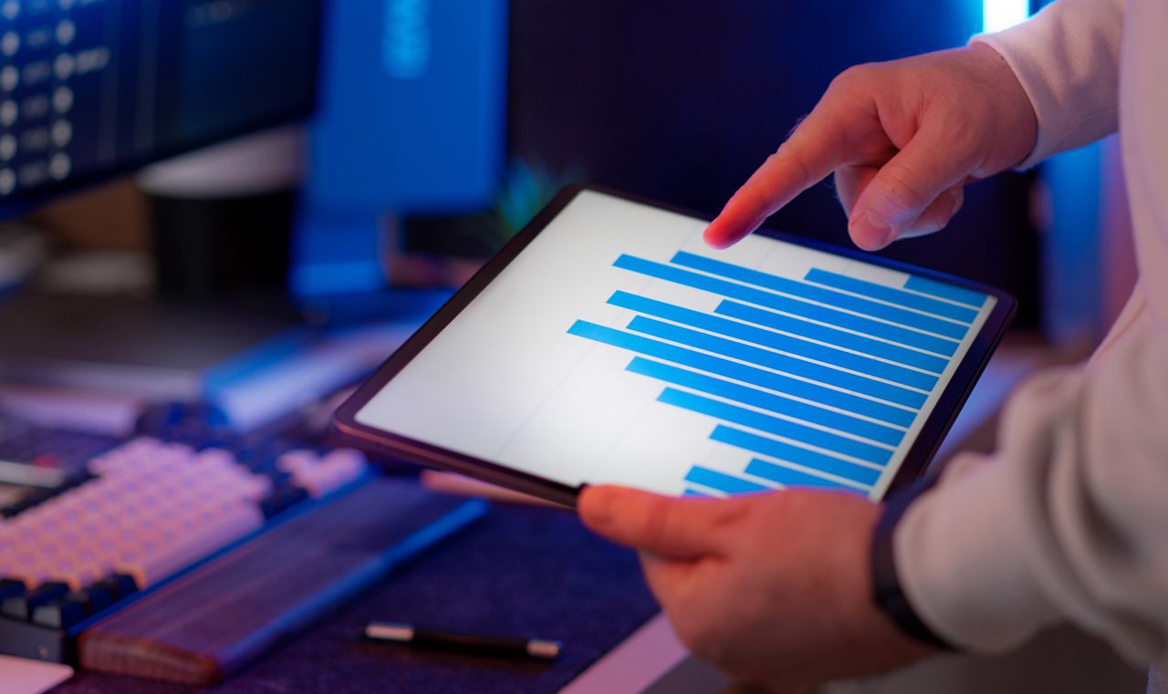 digital Business professional analyzing bar chart on tablet in office setting, highlighting data insights.